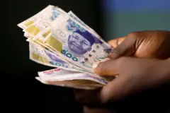 Wani mutum riƙe da takardun kuɗi na naira 