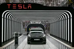 Logotipo da Tesla e carro cercado por luzes