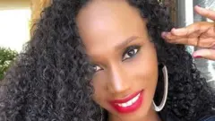  Mange Kimambi arimo kumwenyura areba muri 'camera'. Afite imisatsi miremire.