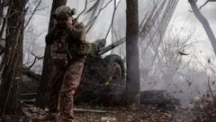 Украинский военный стреляет из гаубицы 