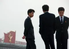 양복을 입은 세 명의 젊은 북한 남성