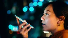 Jovem asiática gravando uma mensagem de voz