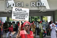 Un partisan de Tidjane Thiam, qui a démissionné de la présidence du Parti démocratique de Côte d'Ivoire (PDCI), tient une pancarte sur laquelle on peut lire « oui à une élection démocratique, transparente, inclusive et pacifique » devant le siège du parti à Abidjan, le 12 mai 2025.