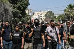 مسلحون فلسطينيون يسيرون في شوارع جنين في أعقاب غارة شنتها القوات الإسرائيلية في 23 مايو/ أيار 2024