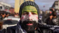 আসাদের পতনের পর মুখে পতাকার রং মেখেছেন এক সিরিয় নাগরিক