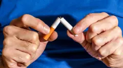 Homem partindo cigarro ao meio