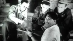 Қабрдан чиқарилган бош чаноғини ушлаб турган антрополог Михаил Гарасимов. 