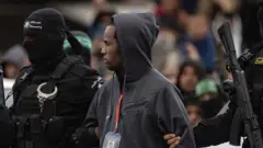 Hamas escolta o refém israelense Avera Mengistu antes de entregá-lo à Cruz Vermelha em Rafah, sul da Faixa de Gaza, sábado, 22 de fevereiro de 2025