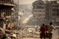 Palestinos caminan cerca de una zona donde militantes de Hamás y miembros del Comité Internacional de la Cruz Roja (CICR) buscan los cuerpos de rehenes israelíes entre los escombros de la ciudad de Gaza, el 5 de noviembre.