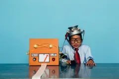 Um menino de camisa social e gravata simula que está sendo submetido a um detector de mentiras