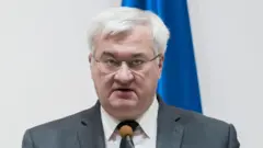 白髪でめがねをかけたシビハ外相