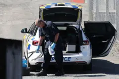 Carro de la policía de Nueva Zelanda después del operativo contra Phillips