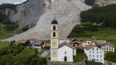 Vilarejo, incluindo igreja, com área de deslizamento atrás