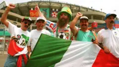 Torcedores italianos aguardam a chegada da sua seleção ao estádio, durante a Copa do Mundo de 1994, gritando e mostrando a bandeira do seu país