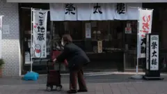 Wata dattijuwa tana tafiya a cikin Tokyo