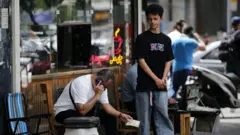 شخص يحمل في يده أوراقاً نقدية إيرانية في طهران