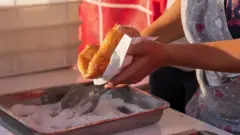 Uma mão segurando uma massa frita