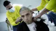 Persona le cortan el cabello en la cárcel. 