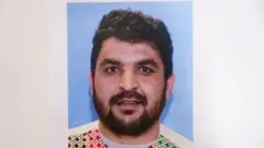 .تصویر رحمان‌الله لکنوال که مقامات آمریکایی منتشر کرده‌اند. مردی گندمی رنگ با ریش و برودی نسبتا کوتاه. ظاهرا لباس سنتی افغانی به تن دارد.