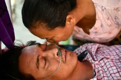 အသက်ရှင်ကျန်ရစ်တဲ့ ကိုတင်မောင်ထွေးကို သူ့ရဲ့ အစ်မဖြစ်သူက အမြန်သက်သာစေဖို့ ဆုတောင်းပေးနေမှု။ 