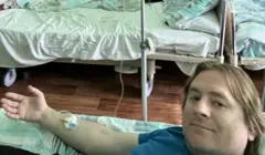 Мужчина в палате химиотерапии с капельницей в руке