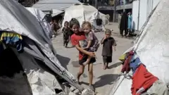 چند چادر آوارگان و کودکانی که در تصویر دیده می‌شوند