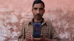 Govind Ram memegang foto anaknya, Surbhi Sharma yang berusia tiga tahun. Surbhi meninggal dunia diduga terkait dengan obat batuk sirop.