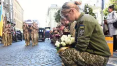 جنود أوكرانيون يؤدون مراسم الجنازة لزميلهم الذي قتل في الحرب مع روسيا