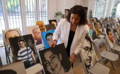 نائبة المدير الإقليمي لمنظمة العفو الدولية، آية مجذوب، تقف بجانب صورة لأفراد عائلات الأشخاص المختفين قسراً في العراق ولبنان وسوريا واليمن يشاركون في فعالية نظمتها المنظمة غير الحكومية الدولية في بيروت في 30 أغسطس/آب 2023، بمناسبة اليوم الدولي لضحايا الاختفاء القسري.