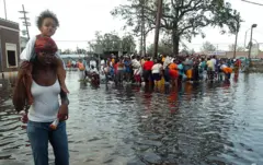Un grupo de sobrevivientes caminando en una calle inundada.