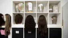 Diversas perucas aparecem em um ateliê