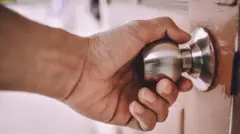 Pessoa segurando uma maçaneta