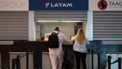 Dos pasajeros en el mostrador de Latam del aeropuerto de Barajas
