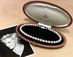 Collar de perlas en un estuche junto a una foto de Marilyn Monroe en la que luce ese mismo collar