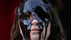 Seorang perempuan tertutup wajahnya dengan cairan minyak.