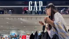 Una joven pasa por delante de una tienda de Gap en China.