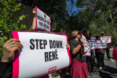 Gente con letreros que dicen "Renuncia, René.".