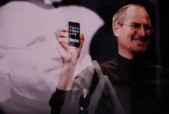 12 Eylül 2017'de Kaliforniya, Cupertino'daki Apple Park kampüsünde bulunan Steve Jobs Tiyatrosu'nda düzenlenen Apple özel etkinliğinde konuşma yapan Apple CEO'su Tim Cook, siyah ceket ve beyaz gömlek giymiş halde, Apple logosu ve gözlüklü, elinde bir iPhone tutan Apple'ın kurucu ortağı Steve Jobs'un yer aldığı bir arka plan görüntüsünün önünde, ellerini kavuşturmuş bir şekilde sahnede duruyor.