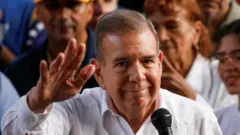 O candidato presidencial da oposição venezuelana Edmundo González discursa para apoiadores durante um comício, em Caracas; ele veste camisa branca e acena com a mão direita