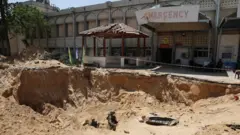 جندي إسرائيلي يقف بالقرب من مدخل نفق يمتد تحت المستشفى الأوروبي في خان يونس بقطاع غزة، وسط العملية البرية المستمرة للجيش الإسرائيلي ضد حركة حماس.