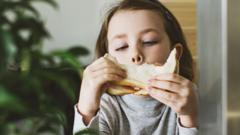 Menina comendo sanduíche de pão de forma branco