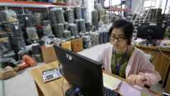 廣州某工廠內一位女性工作人員在電腦上處理發往美國的貨物（資料圖片）