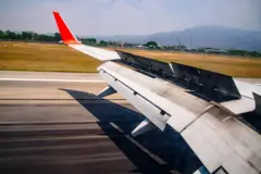 Um avião pousando com os flaps da asa acionados