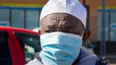 ማስክ ያደረጉ ሰው