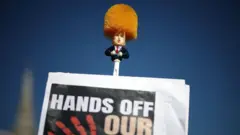 Um manifestante em Londres segurava uma escova de vaso sanitário com a imagem de Trump