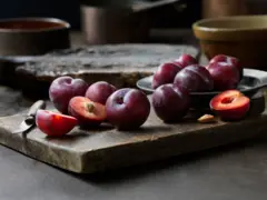 Des prunes exposées sur une planche en bois