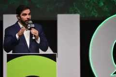 Igor Normando de terno e falando ao microfone 