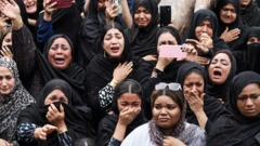 Mulheres, vestidas de preto e com véu, chorando