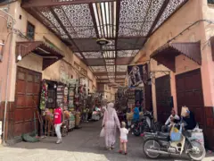 Centro de Marraquexe mostra várias pessoas na rua.