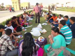  रङ्गीचङ्गी लुगा लगाएर दुबईको एक पार्कमा दशैँको रमाइलो साटिरहेका नेपाली महिला तथा पुरुषहरू